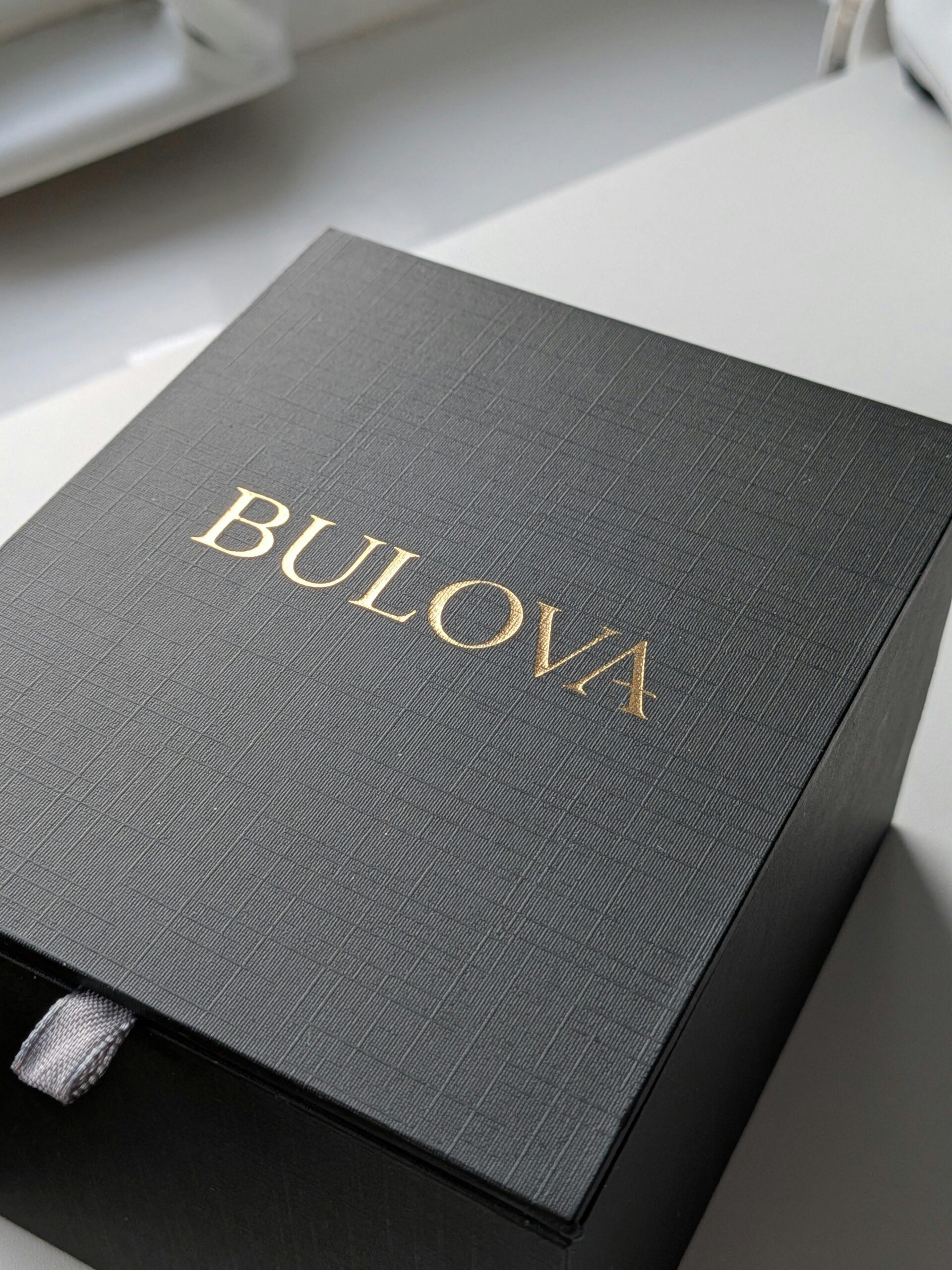 Sophisticated Bulova gift box with textured design, captured in natural daylight.