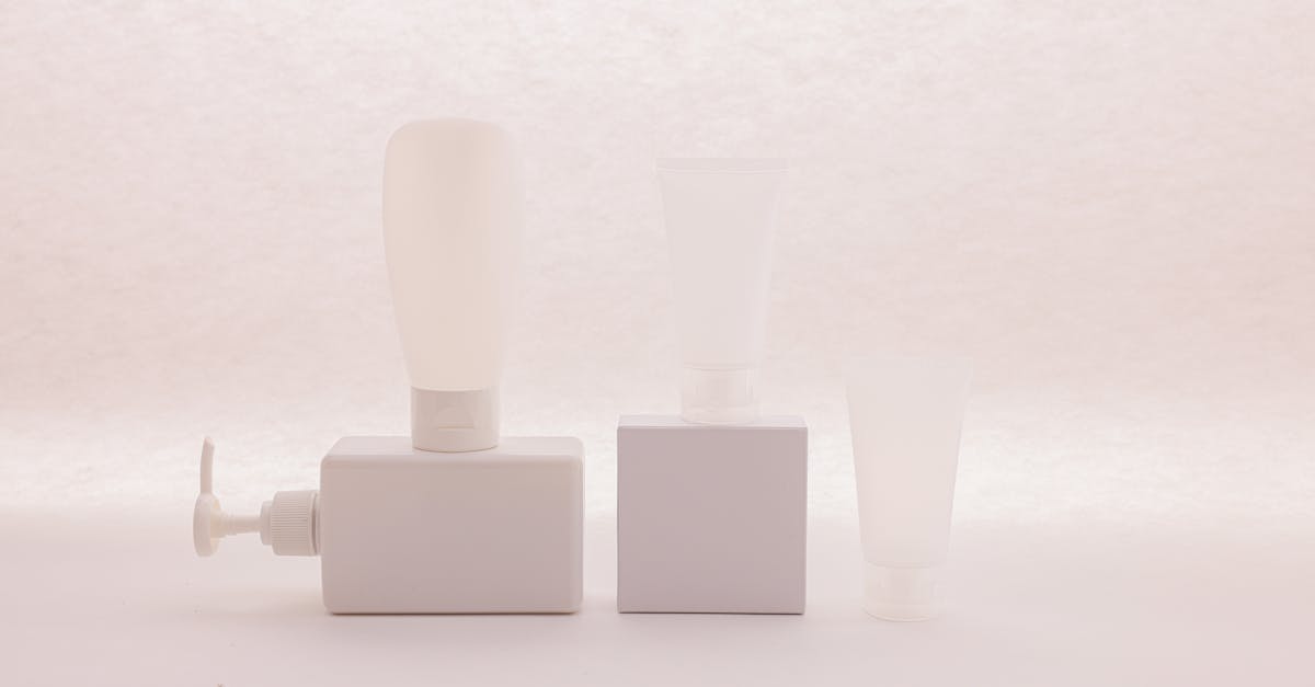 Three white cosmetic containers on a soft background, ideal for product mockups.