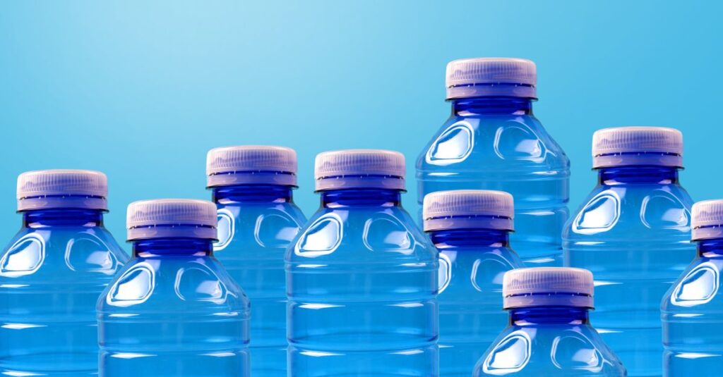 Group of blue plastic bottles symbolizing recycling and zero waste on a gradient background.
