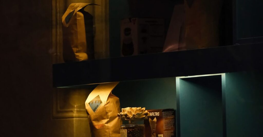 A cozy, dimly lit showcase displaying coffee products and packaging on shelves.