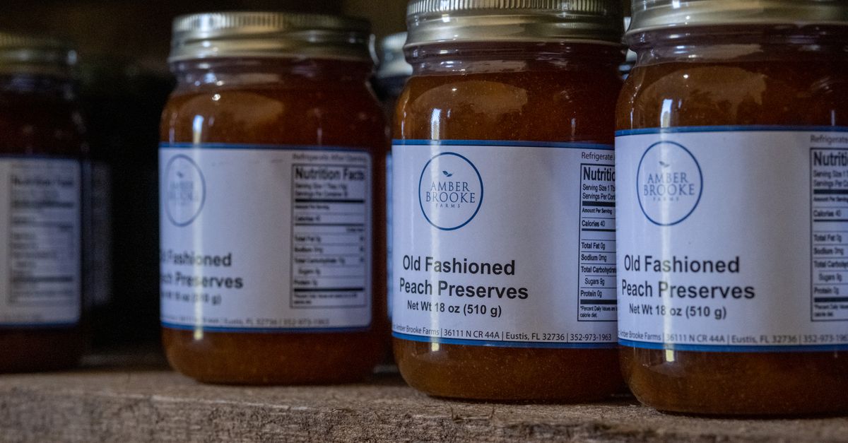 Jars of old fashioned peach preserves on a rustic shelf, ideal for advertisements.