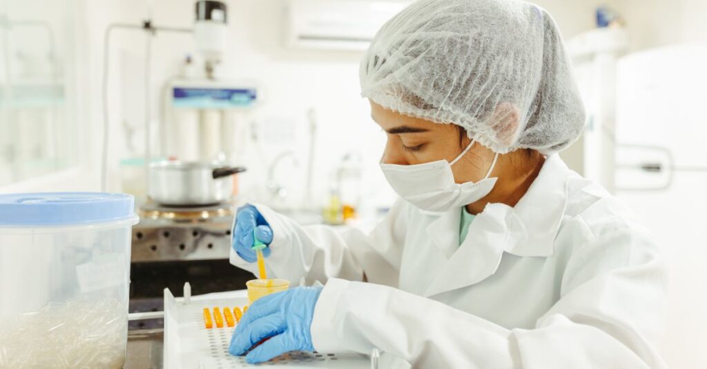A scientist wearing protective gear performs a meticulous experiment in a laboratory setting.