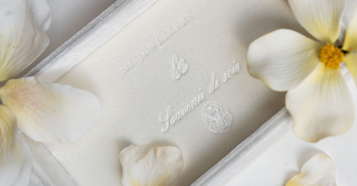 Close-up of a luxurious jewelry package adorned with white petals.
