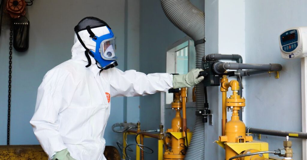 Industrial worker in protective gear inspecting machinery for safety compliance in Indonesia.