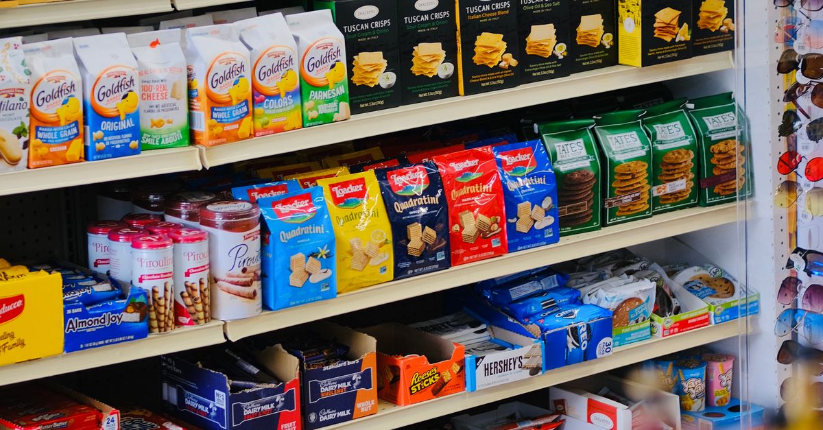 A vibrant display of snacks and beverages on shelves in a store, showcasing variety and abundance.