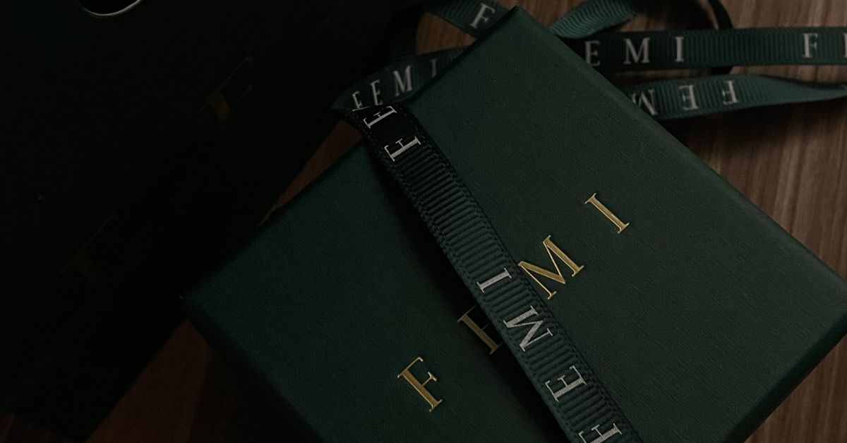 Luxurious dark green gift box with ribbon on a wooden surface, perfect for special occasions.