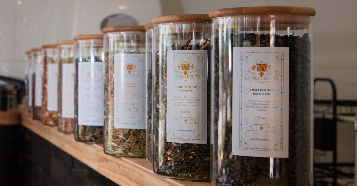 A selection of diverse loose leaf teas in labeled jars neatly arranged on a wooden shelf.