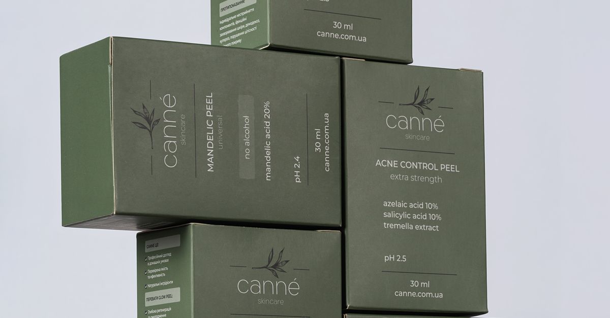Close-up of stacked green boxes of skincare products by Canne featuring labels and benefits.