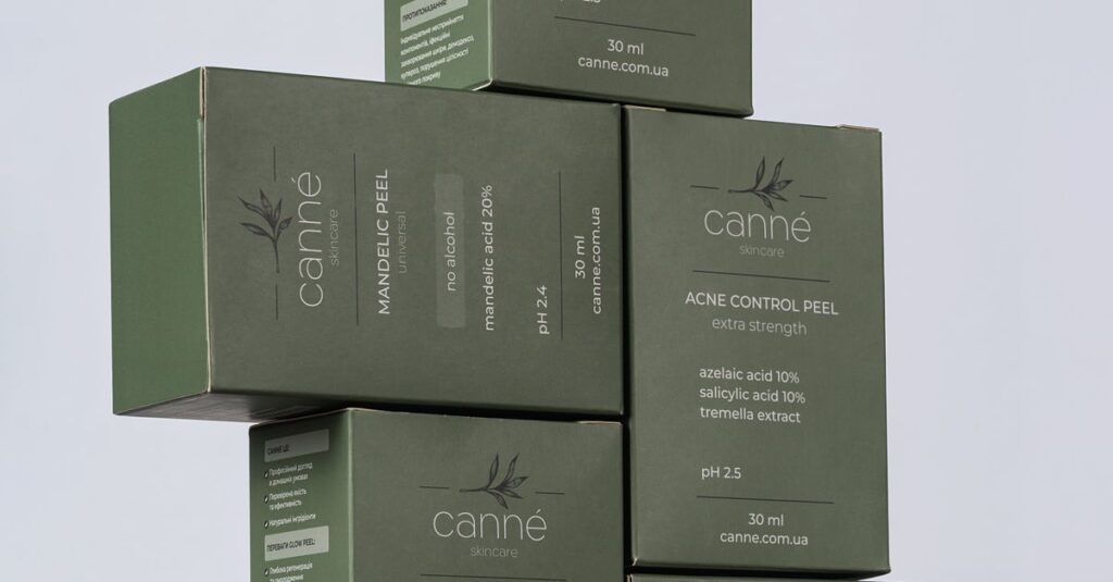 Close-up of stacked green boxes of skincare products by Canne featuring labels and benefits.