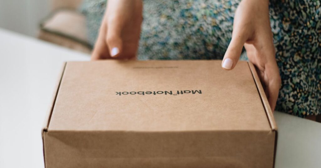 A person holding a closed craft notebook box indoors, focusing on packaging.