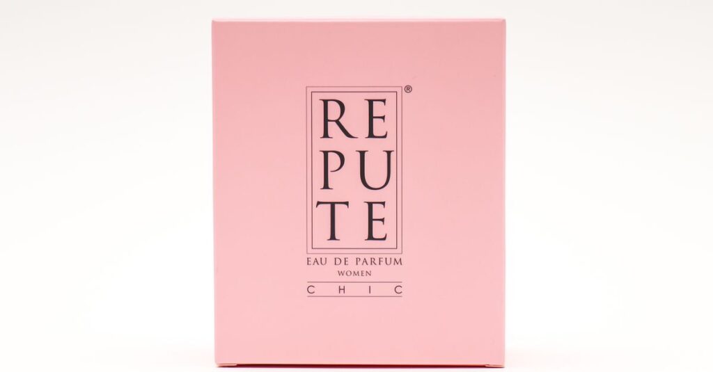 Minimalist design of a luxury perfume box in pink featuring the text 'REPUTE'.
