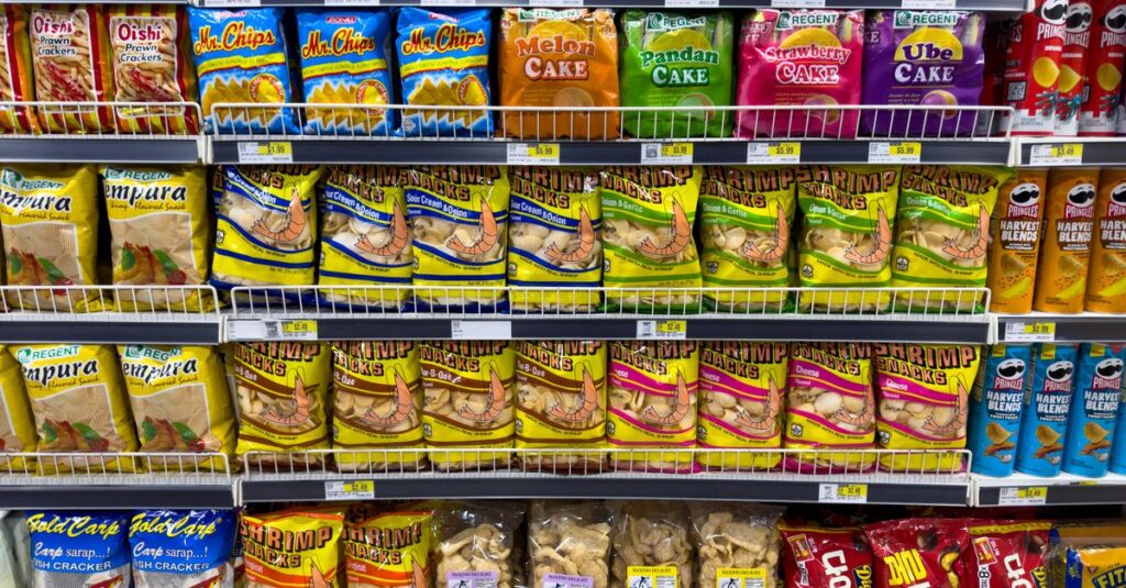 Colorful snack packages neatly displayed in a supermarket aisle showcasing Asian food variety.