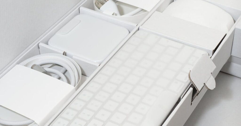 Organized white electronic accessories neatly packed in a box with keyboard and mouse.