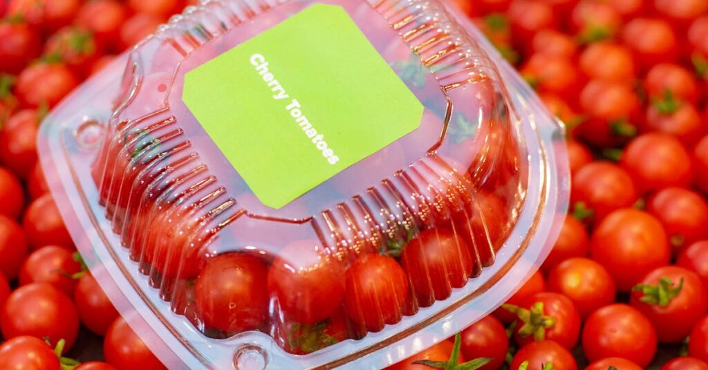 Bright cherry tomatoes in a clear plastic package, ideal for culinary and market visuals.
