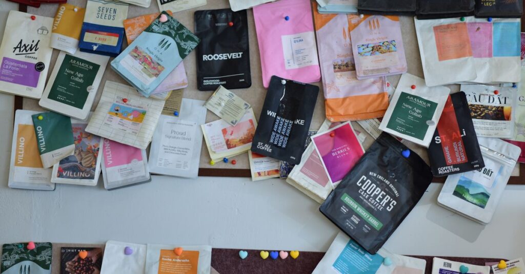 A diverse collection of coffee packages pinned to a bulletin board, showcasing various brands and designs.