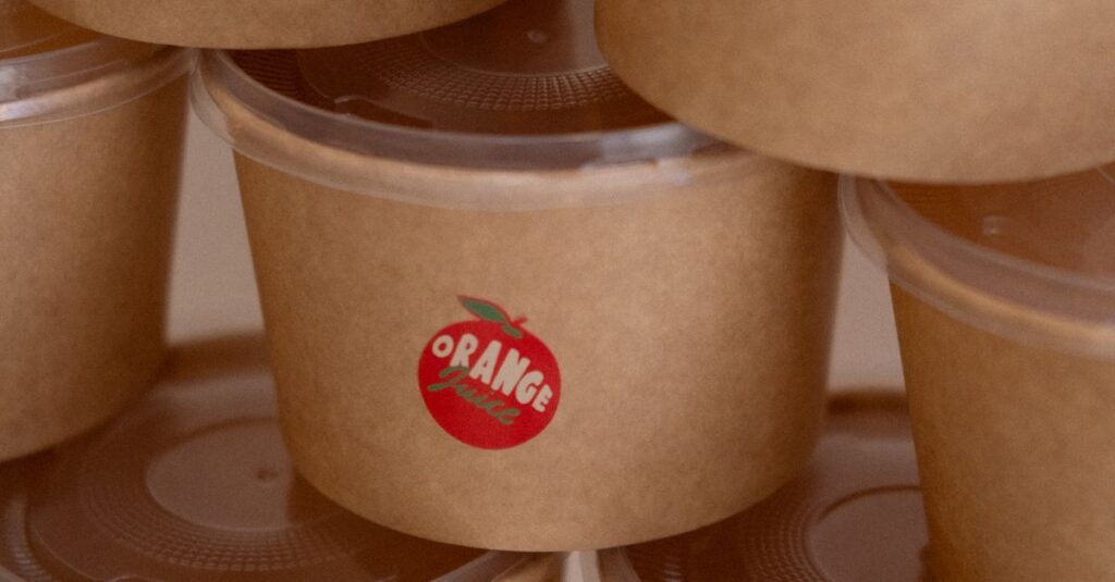 Eco-friendly paper food containers with various fruit labels stacked neatly.