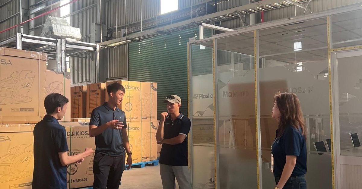 Group of adults discussing in a spacious industrial warehouse setting.