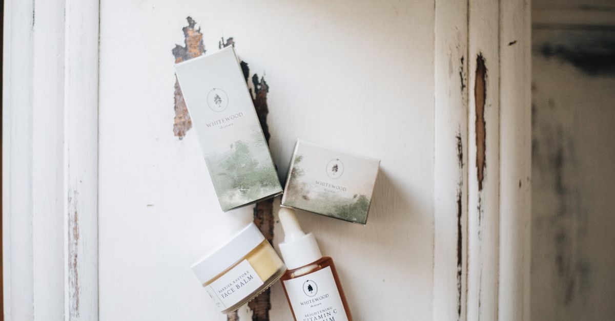 Luxury skincare set with face serum and balm in minimalist style, photographed on a rustic surface.