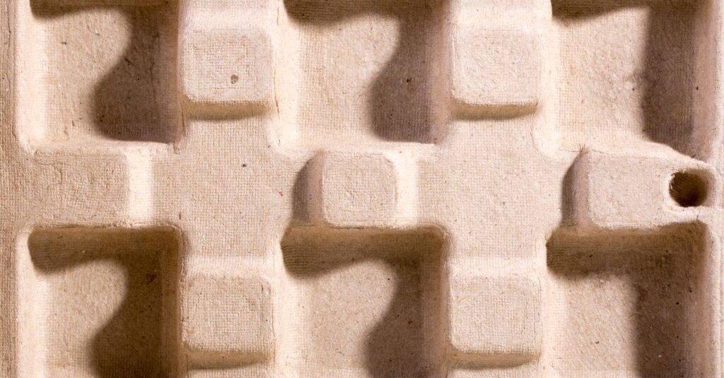 Close-up of an eco-friendly molded fiber packaging material with geometric indentations.
