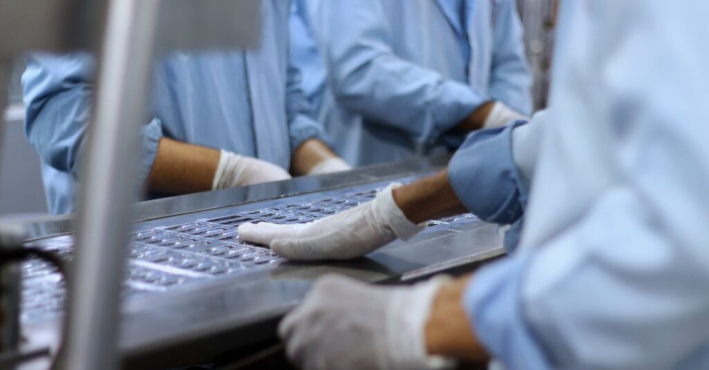 Workers in a pharmaceutical facility packaging tablets in Islamabad.