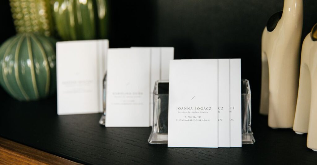 Set of simple visit cards on shelf composed with various stylish vases and decorative figurines in modern office