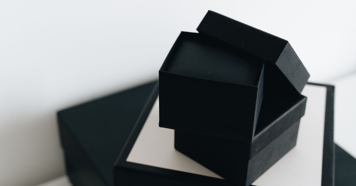 Minimalistic black cardboard boxes arranged in a modern geometric composition.