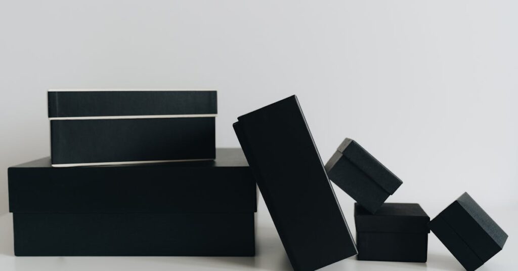 A minimalist display of black gift boxes of varying sizes against a white background.