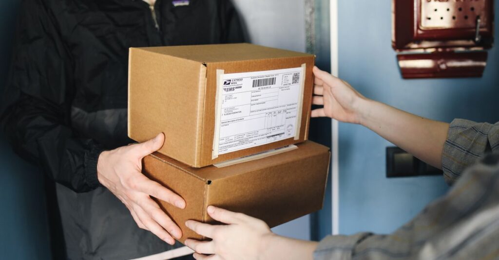 Close-up of hands exchanging cardboard boxes indoors, symbolizing delivery service.