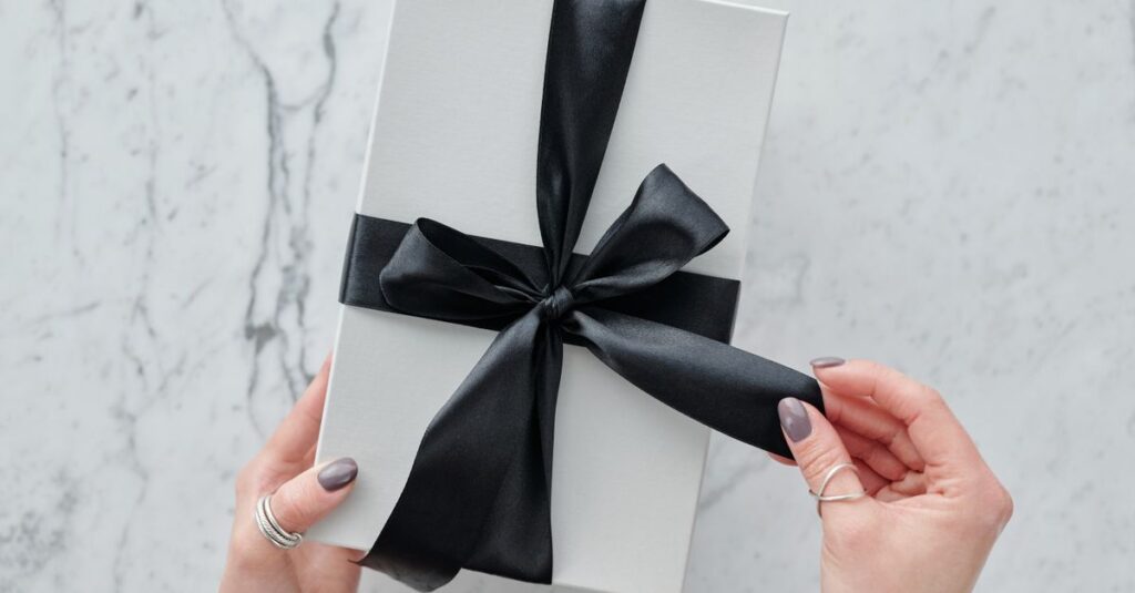 A sleek white present tied with a black satin ribbon, providing a touch of luxury. Ideal for gift themes.