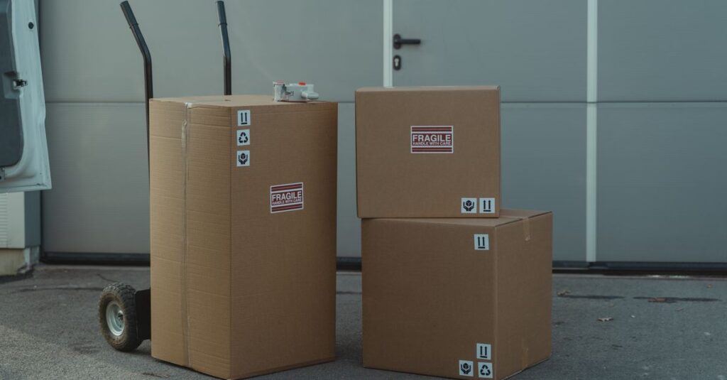 Three cardboard boxes on a dolly, ready for shipping outside a warehouse.