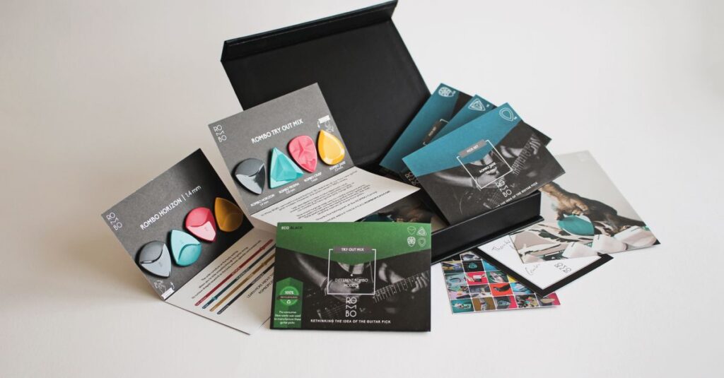 A variety pack of colorful guitar picks with packaging and promotional materials.