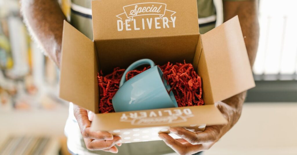Man holding a box with a special delivery coffee mug inside.