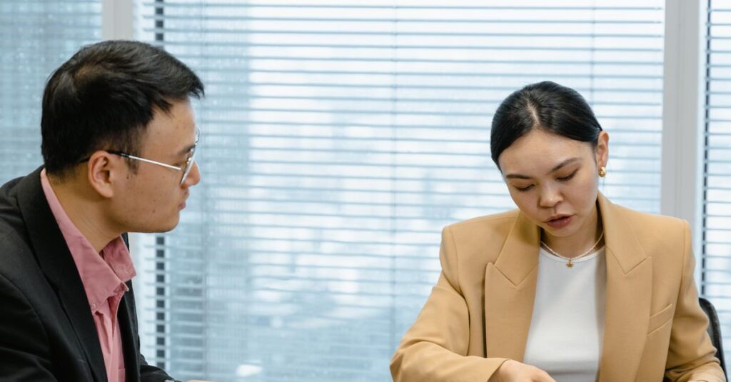 Two business professionals discussing documents in a modern office.