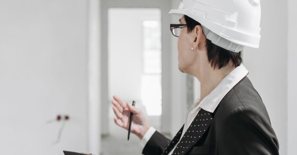 A professional engineer in a suit and hard hat inspecting a construction site with a clipboard.