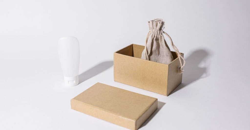 Stylish minimalist mockup featuring a cardboard box, linen pouch, and cream tube on a white background.
