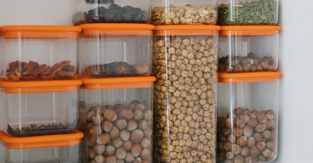 Various nuts and grains stored in transparent plastic containers with orange lids, organized neatly.