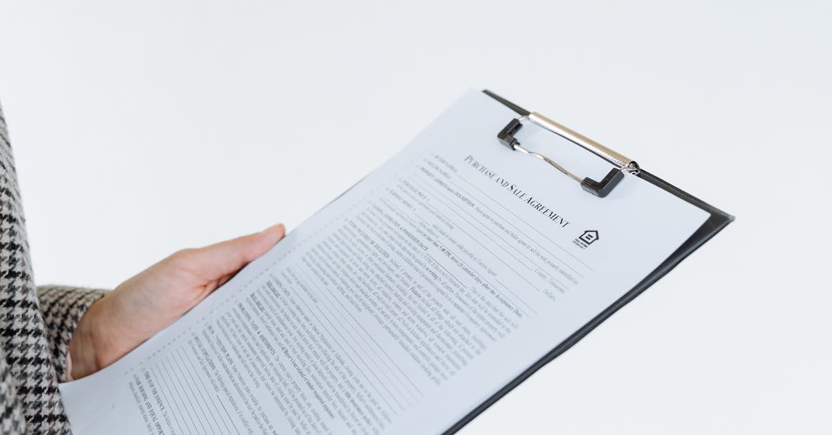 Person holding a filled contract on a clipboard with a pen against a white background.