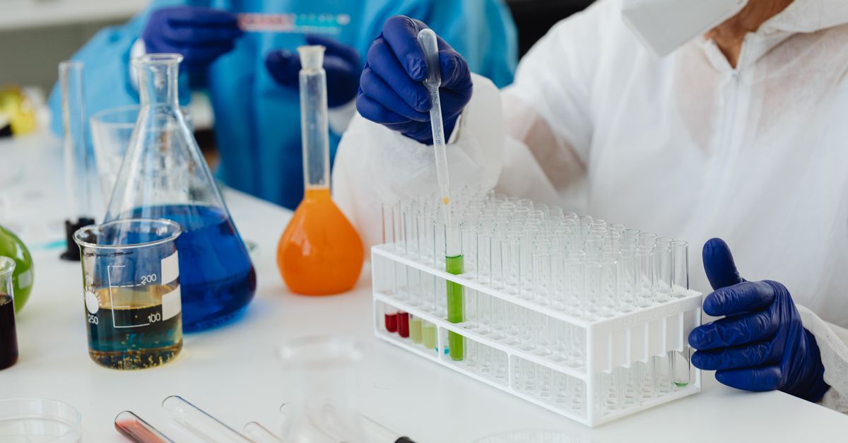 Laboratory scientists working with test tubes and liquids, performing chemical experiments.