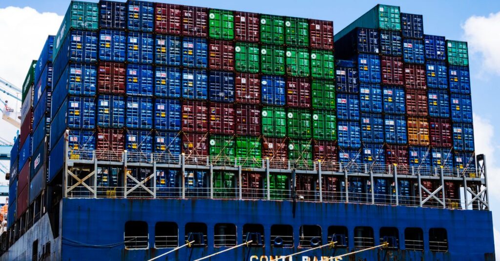 Stacked cargo containers on a massive ship at the harbor, symbolizing global trade.