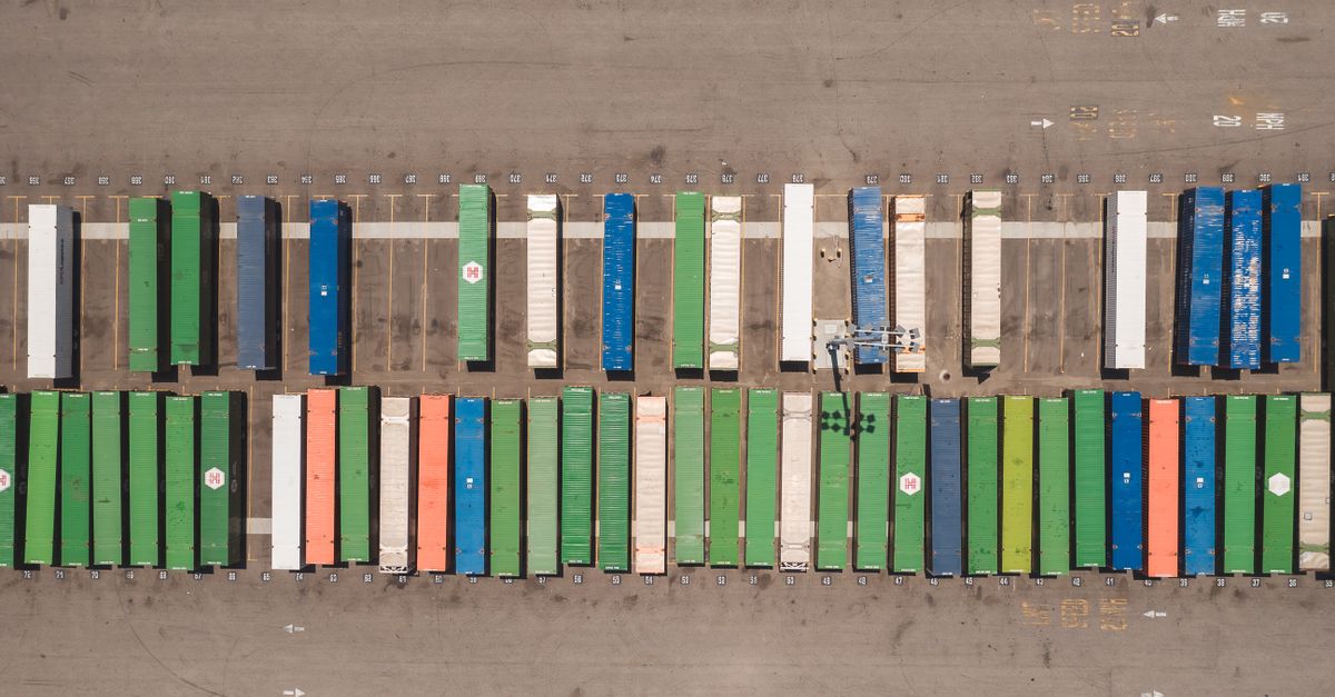 Top view of neatly arranged cargo containers in a shipping port, highlighting logistics and global trade.