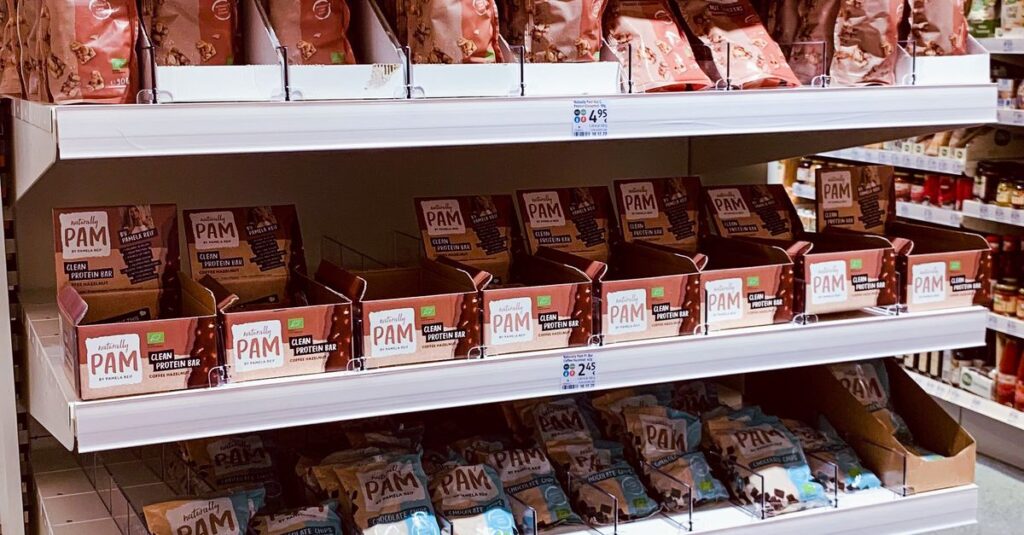 An organized display of assorted snack bags on grocery store shelves.