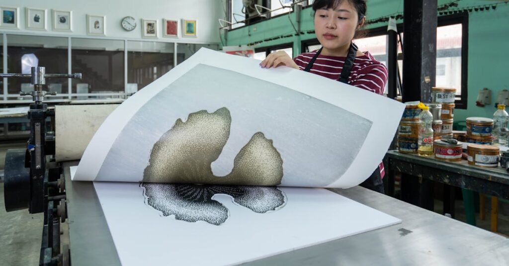 A woman inspects a freshly printed design in a modern printmaking studio, surrounded by printing tools and equipment.