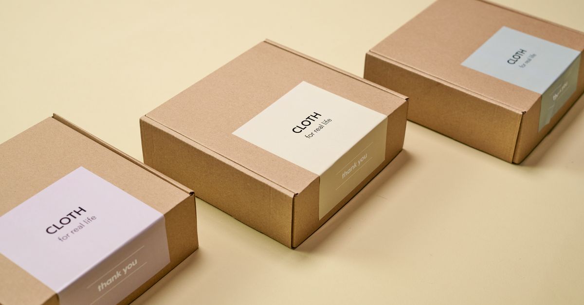 Three minimalist cardboard packages labeled 'CLOTH' on a yellow background.