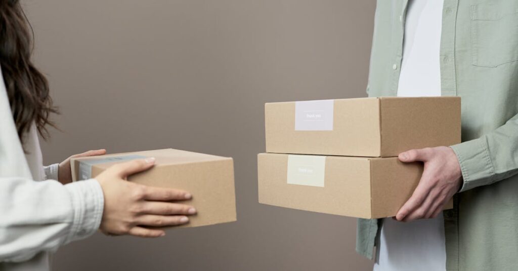 Two people exchanging cardboard boxes indoors, emphasizing teamwork and logistics.