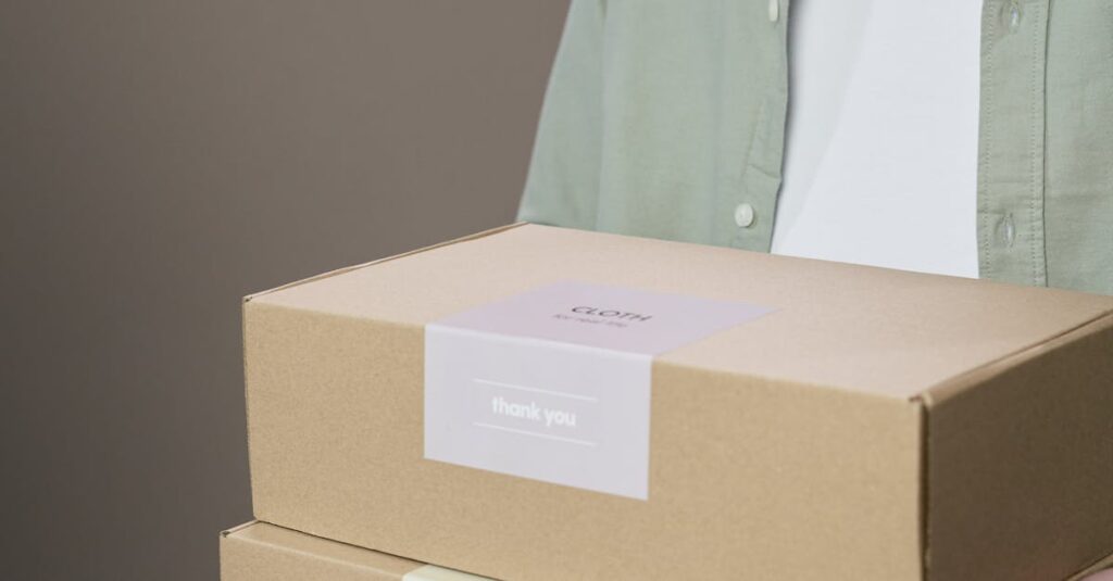 A person holding two labeled cardboard boxes against a neutral background.