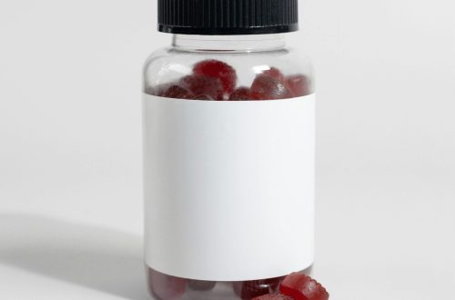 Close-up of a jar containing red gummy vitamins with a blank label, suitable for supplement branding.